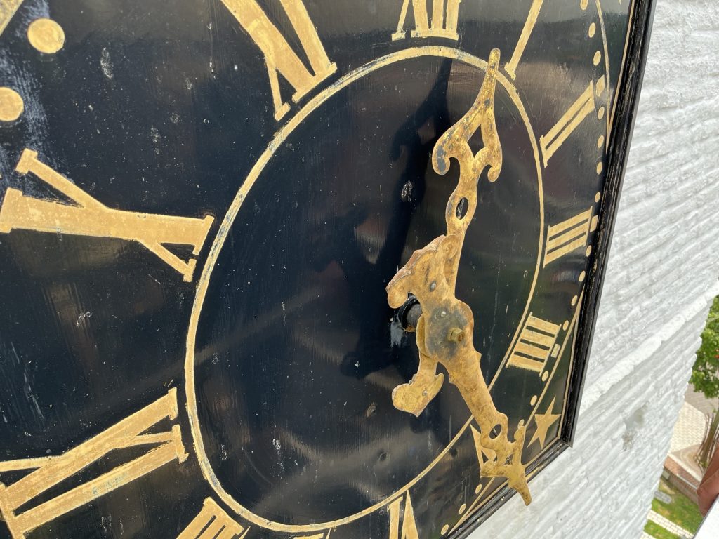 Wijzerplaat van De Witte Kerk in zwart en gouden kleur.